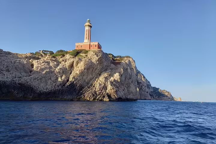 Capri classic boat tour view of Punta Carena lighthouse on cliffs above the Tyrrhenian Sea