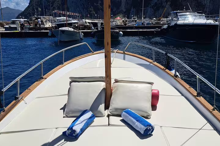 Sunbed and towels on classic boat bow in Capri marina, ready for Capri Essence 4-hour private tour