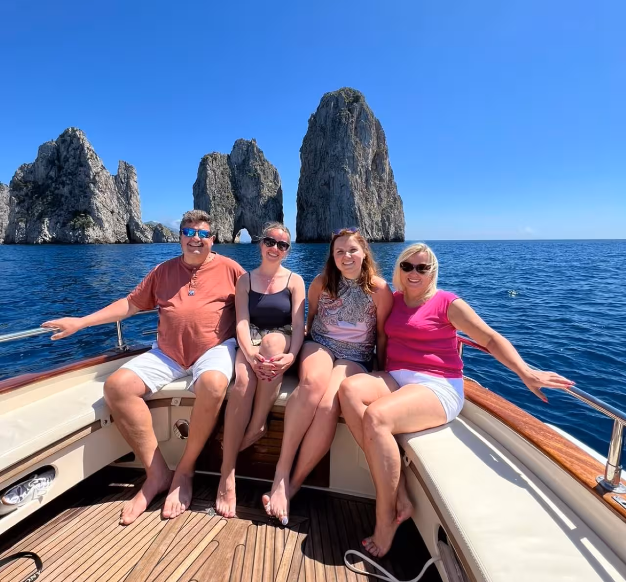 Family relaxing on a private Capri boat tour with Faraglioni sea stacks, scenic cruise and swim stops