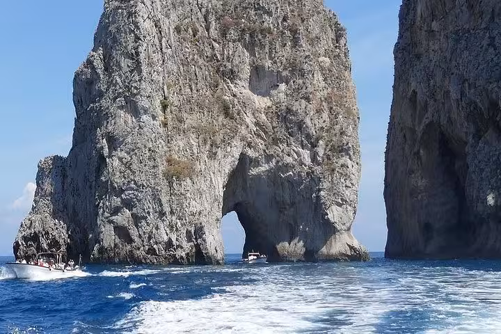 Explore the stunning Faraglioni rock formations by boat on a Capri and Sorrento coast tour from Naples.