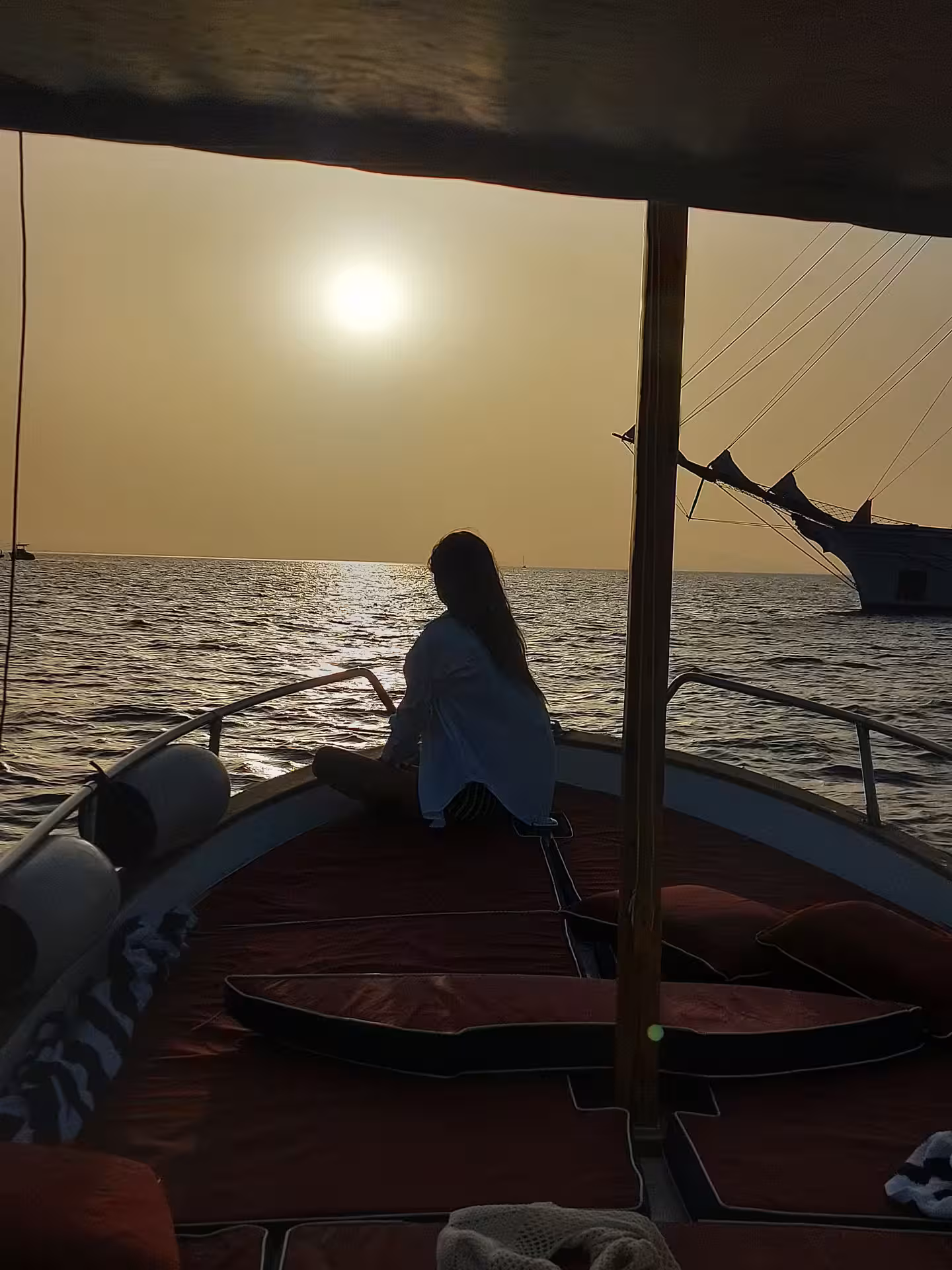 Silhouette on sailboat at sunset, From Dusk Till Night immersive experience with ocean twilight views