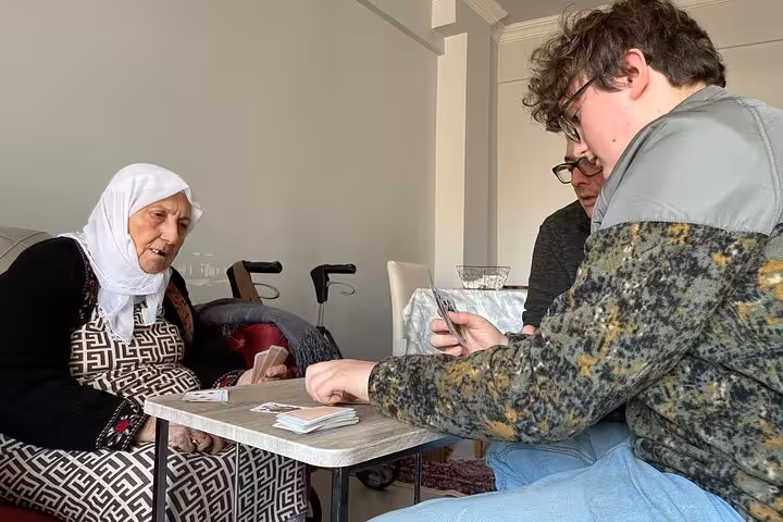 Guests play cards with a local Turkish grandma at home, enjoying authentic afternoon Turkish tea experience