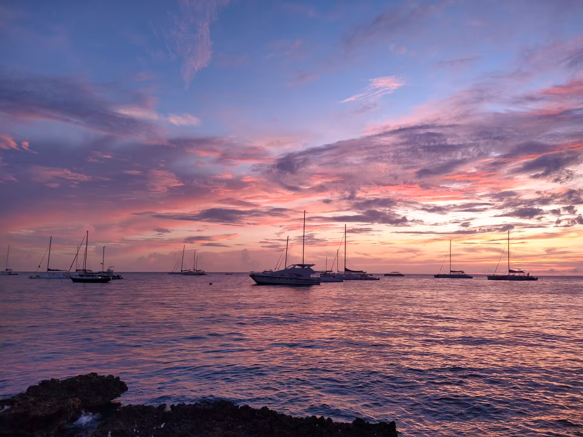 Caribbean sunset with sailboats anchored offshore, Dominican Republic getaway featuring romantic ocean views and cruises