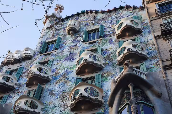 Upward view of Casa Batlló’s colorful balconies and windows, a Gaudí masterpiece included in the La Pedrera morning tour