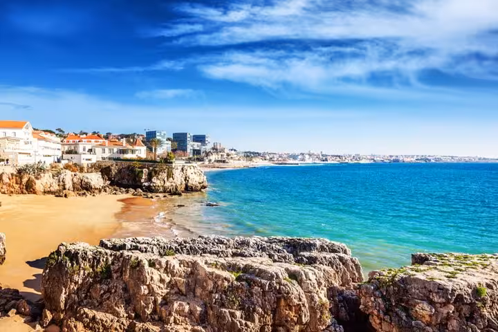 Picturesque coastline of Cascais with rocky cliffs and clear waters, featured in Sintra & Cascais Half-Day Panoramic Experience.