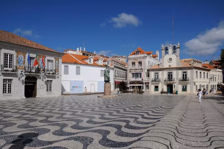 Scenic view of Cascais Town Hall Square with patterned stone pavement and historic buildings under a clear blue sky.