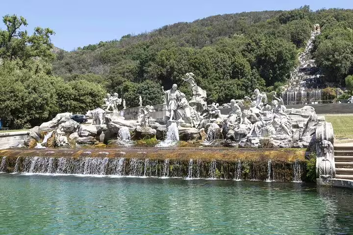 Baroque statues and cascading fountains in the grand park of Caserta Royal Palace viewed on a private guided gardens shuttle tour