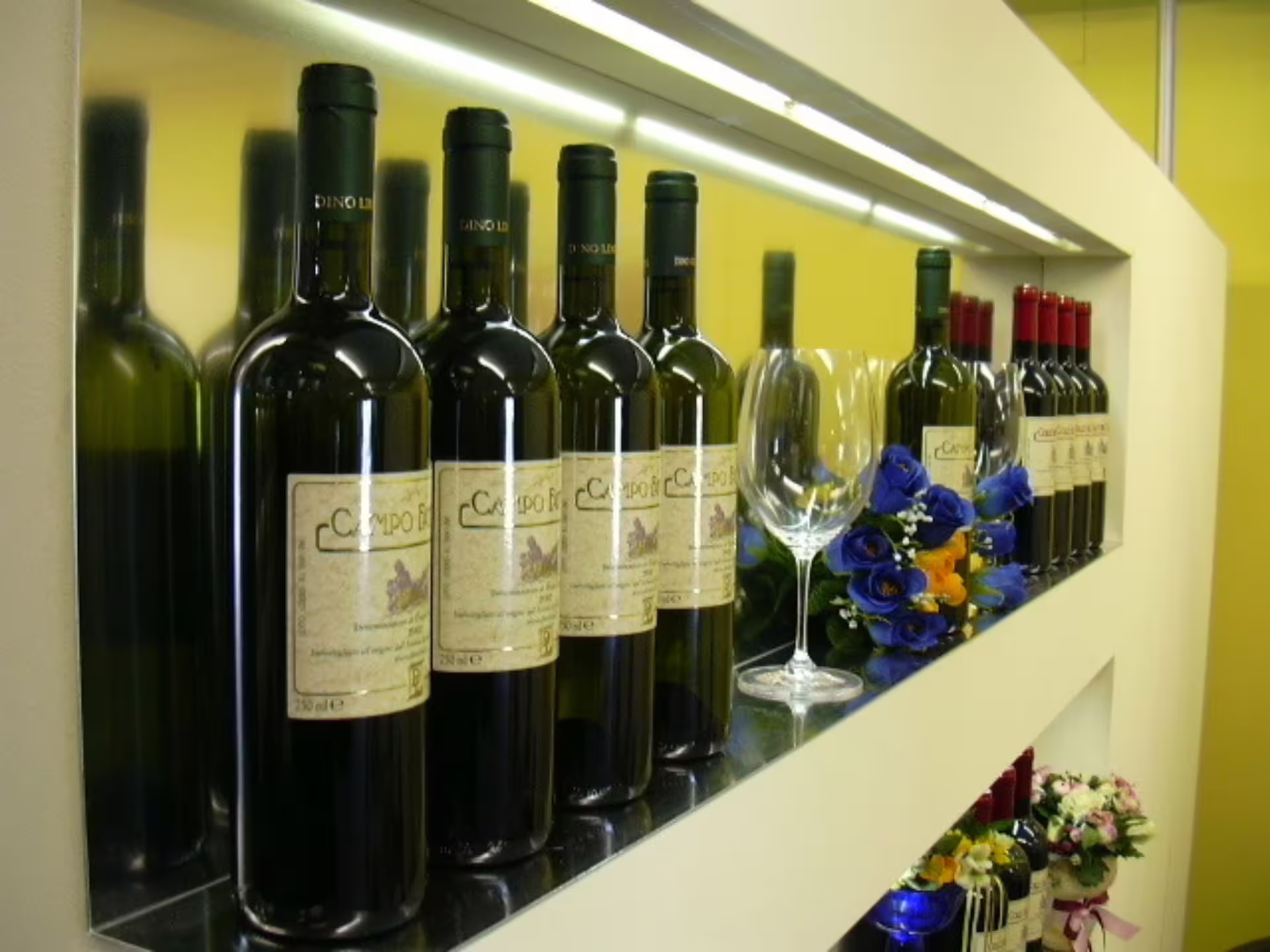 Elegant wine bottles displayed with glasses and flowers at Castelli Romani, perfect for a tasting tour experience.