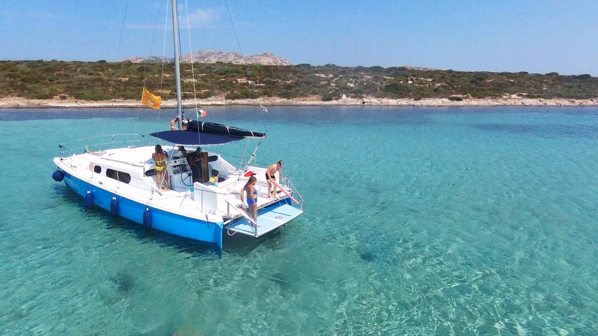 Catamaran anchored in crystal-clear waters near Stintino, perfect for a Gulf of Asinara sailing adventure.