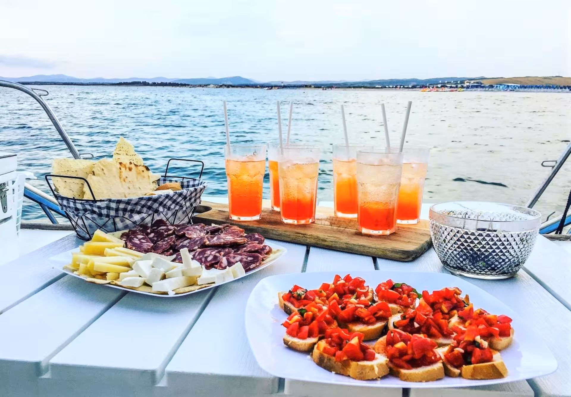 Enjoy a gourmet spread of Italian antipasti and cocktails on a catamaran in the Gulf of Asinara near Stintino.