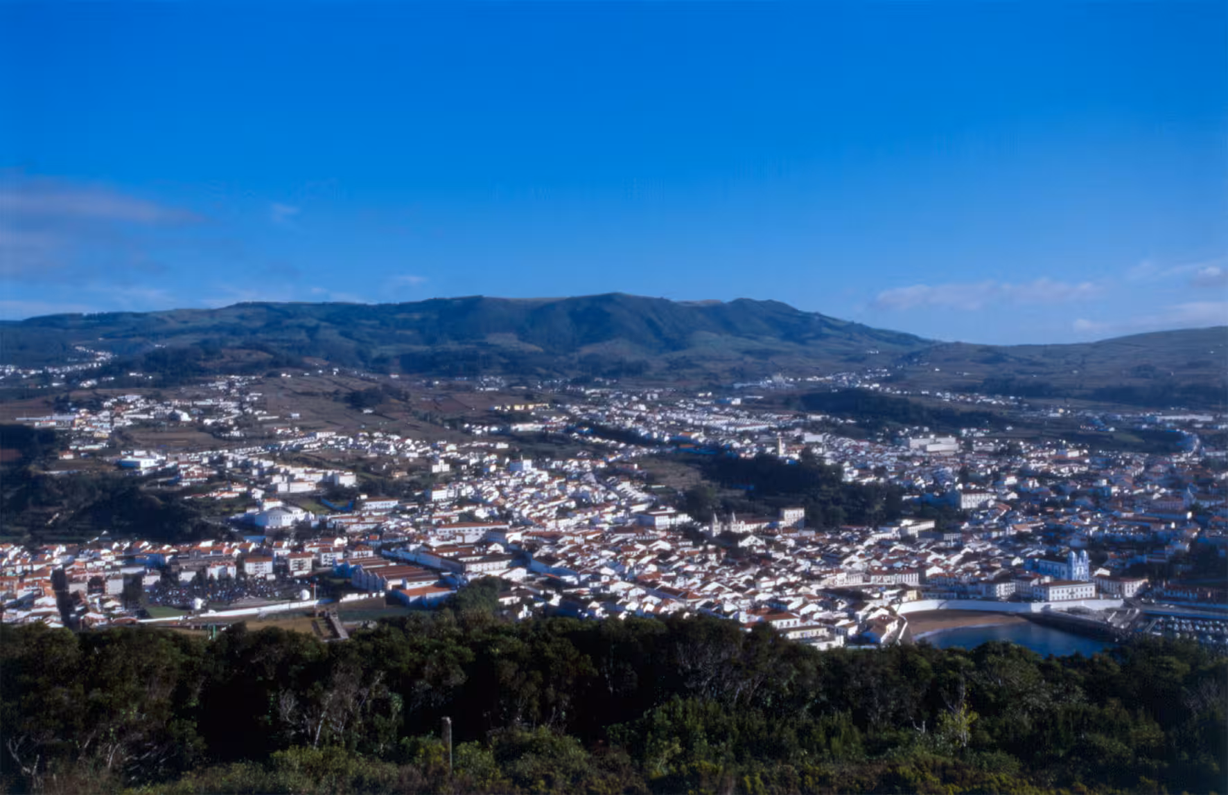 Panoramic view of a central island town and green hills on the Midday in the center of the island morning tour