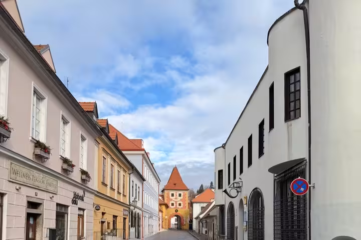 Historic Cesky Krumlov street leading to medieval gate tower, scenic walking stop on Salzburg day trip