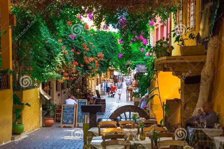 Flower-filled lane in Chania Old Town with tavernas and bougainvillea, charming walk on Rethymno day excursion
