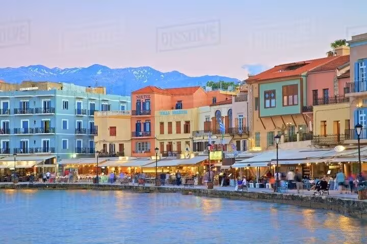 Chania Venetian Harbor waterfront at sunset with cafes and colorful buildings, highlight of Rethymno to Chania tour