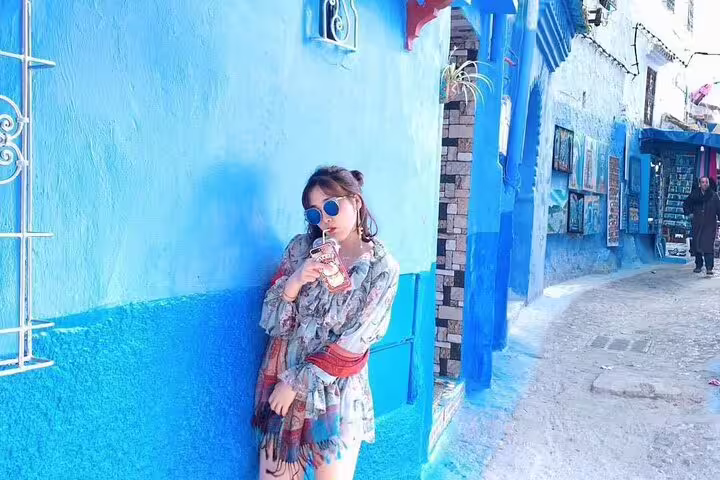 Traveler posing in Chefchaouen blue medina alley on 2-day trip from Casablanca, Morocco Blue City tour