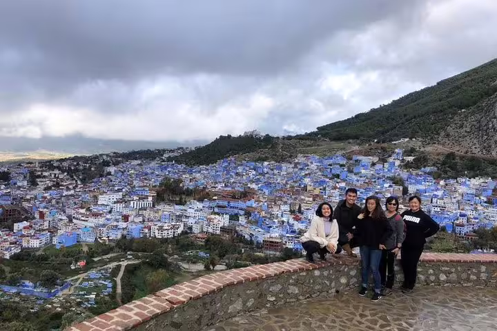 Travelers at viewpoint over blue Chefchaouen medina, must-see stop on Morocco 10 days tour from Casablanca