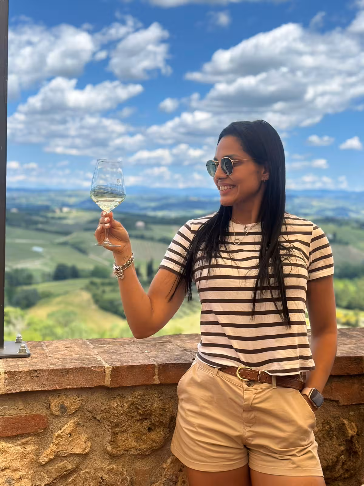 Woman enjoying a glass of wine with scenic Chianti hills in the background during a winery tour in Greve.