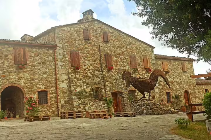 Historic stone winery with black rooster statue in Chianti Classico region on a half-day San Gimignano tour