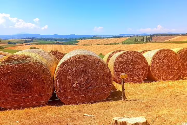 Golden hay bales in rolling Chianti countryside on a sunny afternoon, seen during a private Tuscany wine farm tour