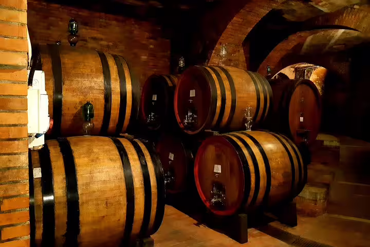 Traditional oak wine barrels in an atmospheric Chianti cellar, featured on a private Tuscany tour with lunch and tasting
