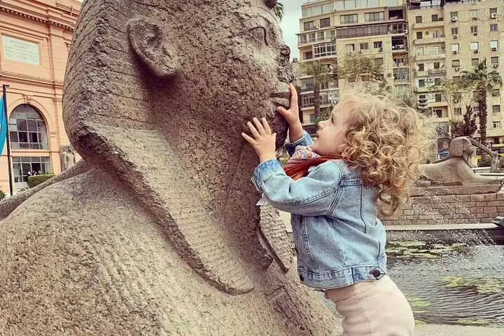 Child touching sphinx statue at Egyptian Museum Cairo during private full-day Cairo and Giza tour