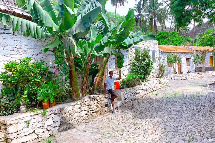 Cobblestone street in Cidade Velha with banana trees and stone houses, seen on a guided Calabaceira Valley hike tour