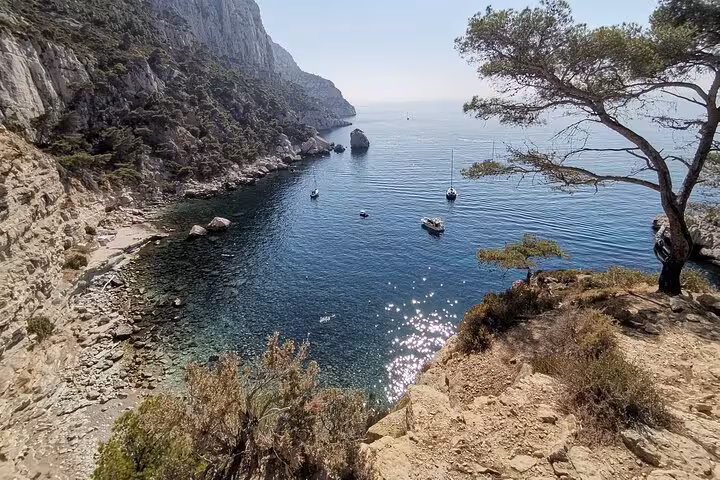 Coastal hiking viewpoint in Calanques National Park from Marseille overlooking boats on a crystal-clear cove