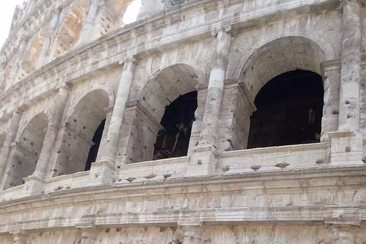 Close-up view of the Colosseum's ancient arches, showcasing its iconic Roman architecture on the express tour.