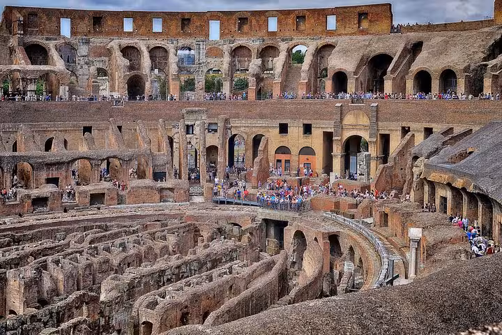 Interior view of the Colosseum with a bustling crowd, highlighting ancient Roman amphitheater design.