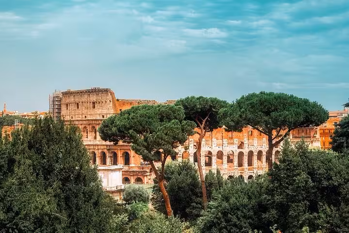Scenic view of the Colosseum surrounded by lush greenery, perfect for an express tour of Rome's iconic landmarks.
