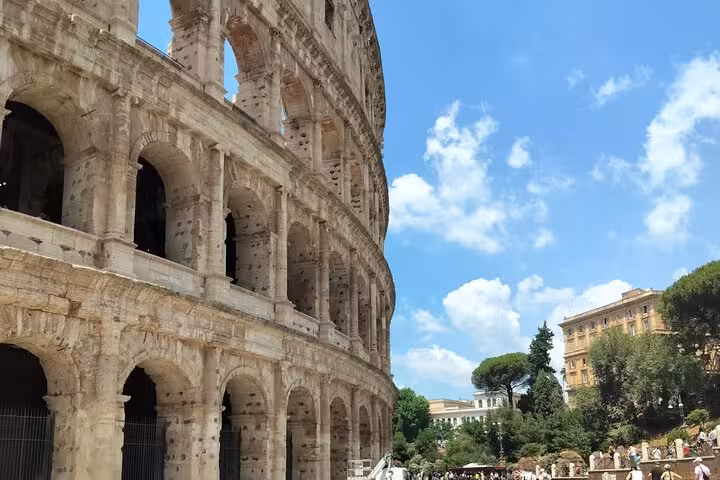 Close-up of the Colosseum arches against a clear sky, showcasing iconic Roman architecture for guided tours in Rome.