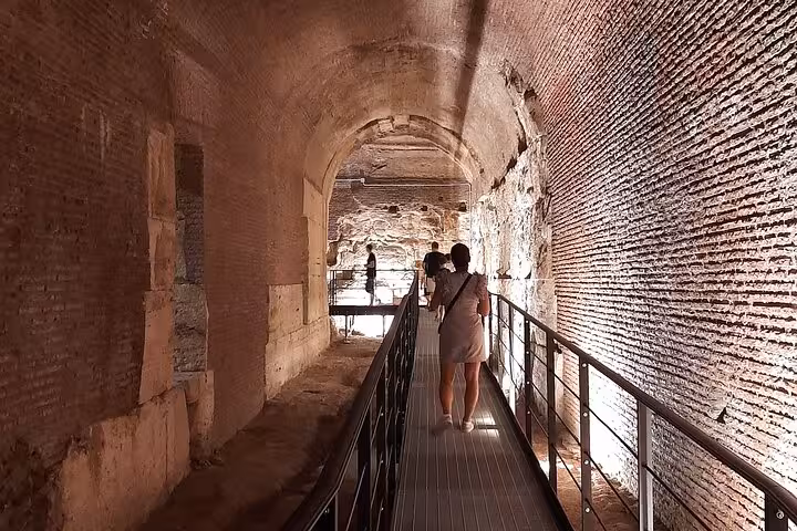 Explore the illuminated underground passageways of the Colosseum on a captivating night tour in Rome.