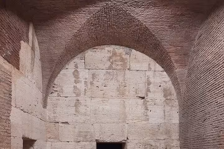 Discover the intricate brick and stone archways within the Colosseum during an exclusive night tour in Rome.