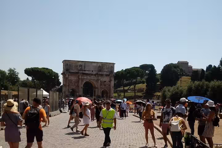 Visitors exploring the Roman Forum near the Arch of Constantine, a key site on the Colosseum express tour.