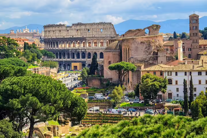 Panoramic view of the Colosseum and Roman Forum ruins in Rome, Italy, seen from above on a small-group guided tour route