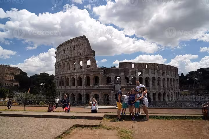 Tourists enjoying a sunny day at the iconic Colosseum, included in the Rome historical tour with transportation.