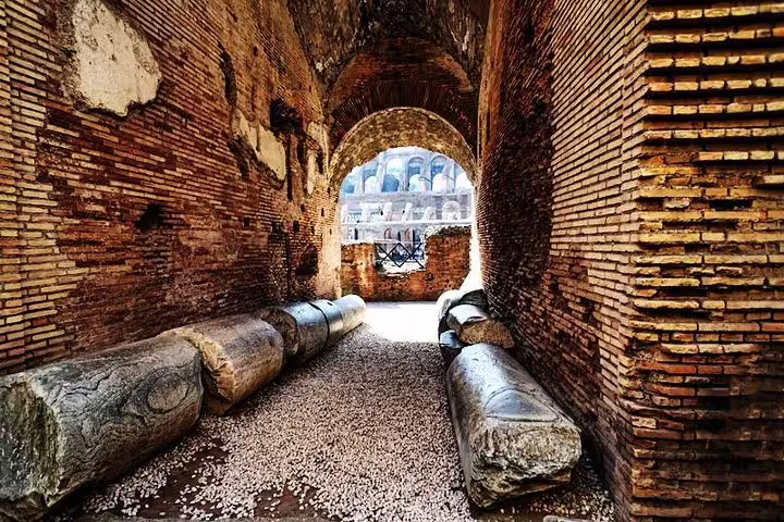 Historic underground corridor with fallen marble columns inside the Colosseum, part of a Rome arena and Forum private tour