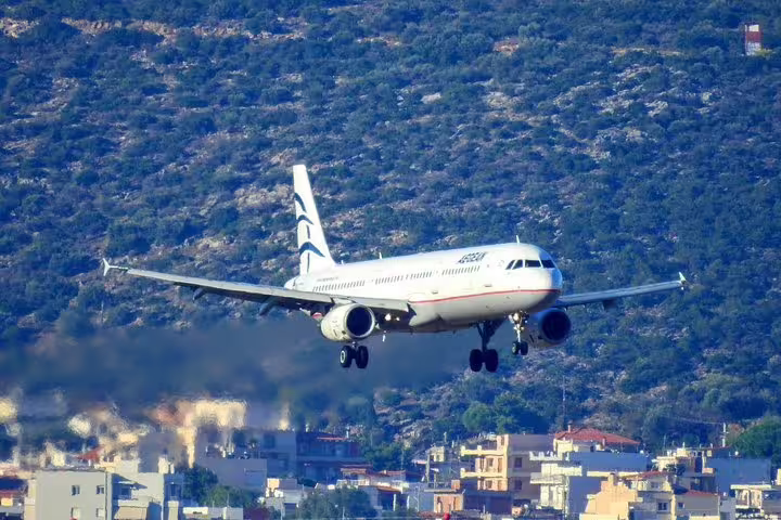 Commercial airplane approaching landing over city, ideal for airport pickup services and arrival transfers