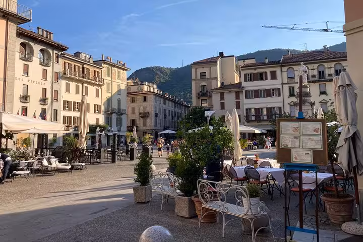 Como old town piazza with cafes and historic buildings, walking time on Milan to Como Bellagio and Lugano tour