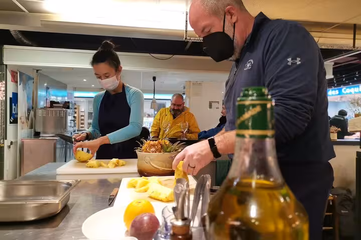 Hands-on cooking workshop in Avignon as guests chop fresh fruit and prep Provençal dishes with a chef