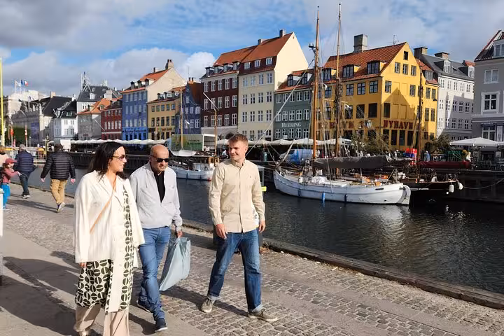 Small group exploring colorful Nyhavn district on a cultural walking tour.