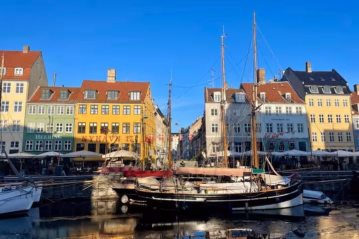 Colorful historic buildings and a sailboat at Nyhavn Harbor, capturing the charm of Copenhagen's walking tour.