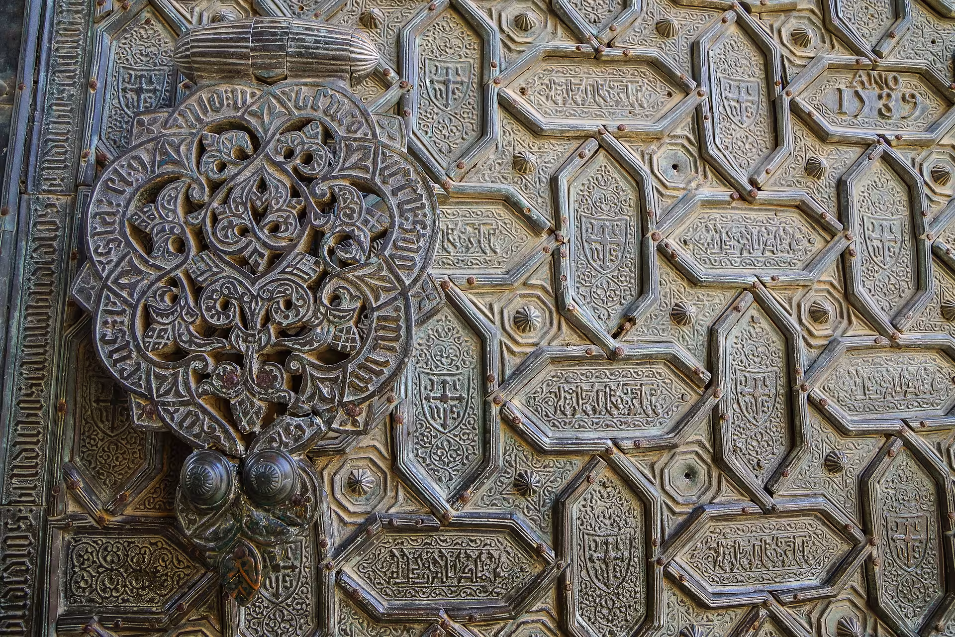 Intricate Islamic geometric patterns adorn the ancient wooden door of the Cathedral Mosque in Cordoba.