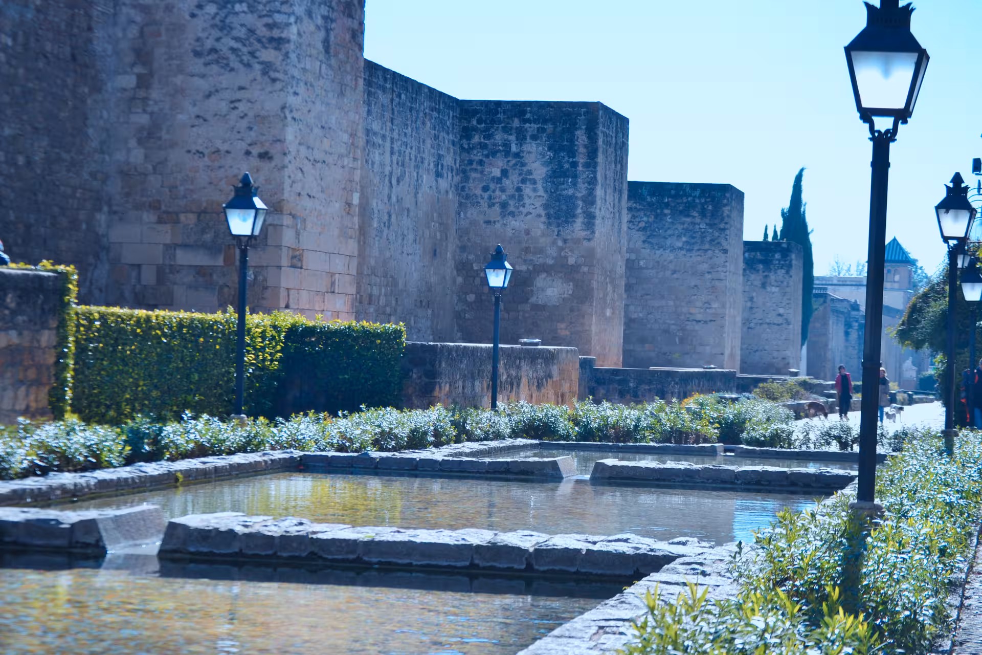 Historic fortress walls and reflecting pool on a free tour in Córdoba, scenic walk near the Alcázar gardens