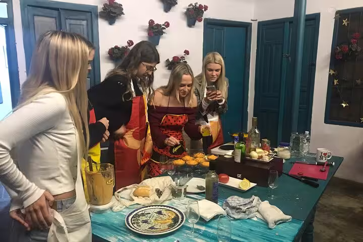Group of people in Córdoba enjoying a hands-on paella and salmorejo cooking class, preparing fresh ingredients.
