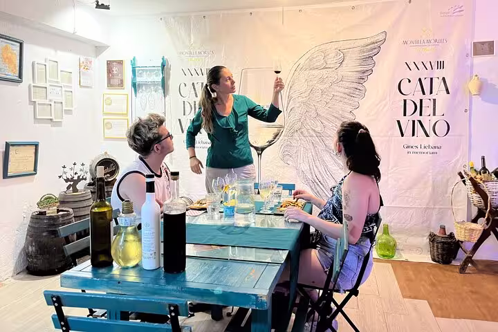 A guide presents a wine glass during a Cordoba sunset wine and cheese tasting, engaging guests with local flavors.