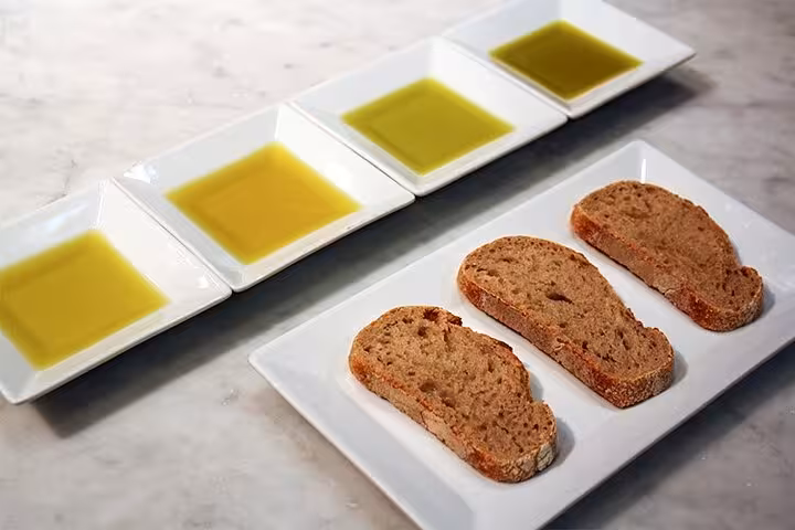 Corfu private tour tasting with local olive oil samples and rustic bread on marble table in Greece