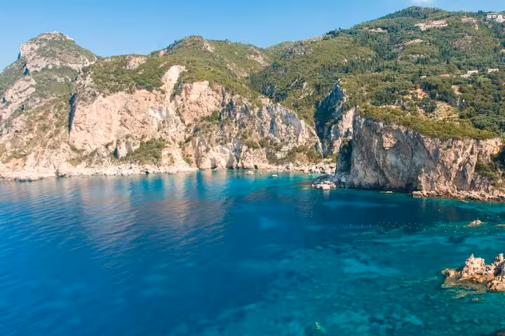 Turquoise bay and rocky coastline on Corfu private tour, scenic stop for photos along the Ionian Sea
