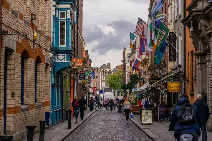 Cork City street scene with colorful shops and flags, visited on the Dublin to Blarney Castle, Cashel Rock day tour