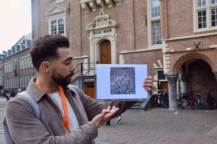 Local guide shows WWII photo outside Haarlem’s Corrie ten Boom House on a WW2 walking tour experience